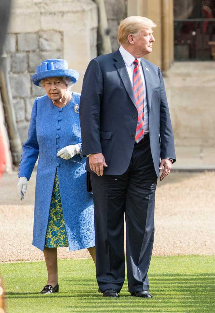 Donald Trump standing in front of Queen Elizabeth II